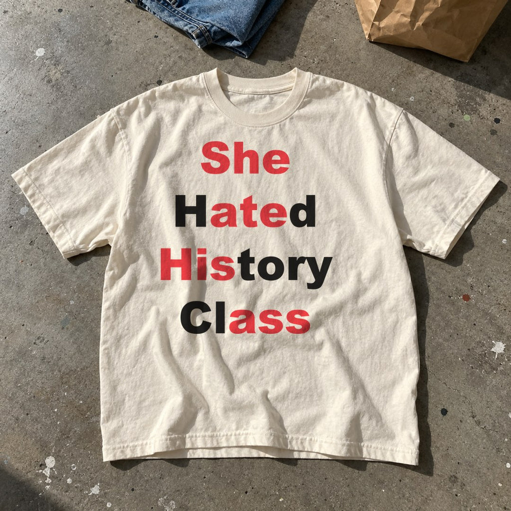 She Hated History Class Shirt laid flat on a concrete floor