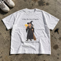 Out of Spells Not Out of Shells Shirt laid flat on a concrete garage floor
