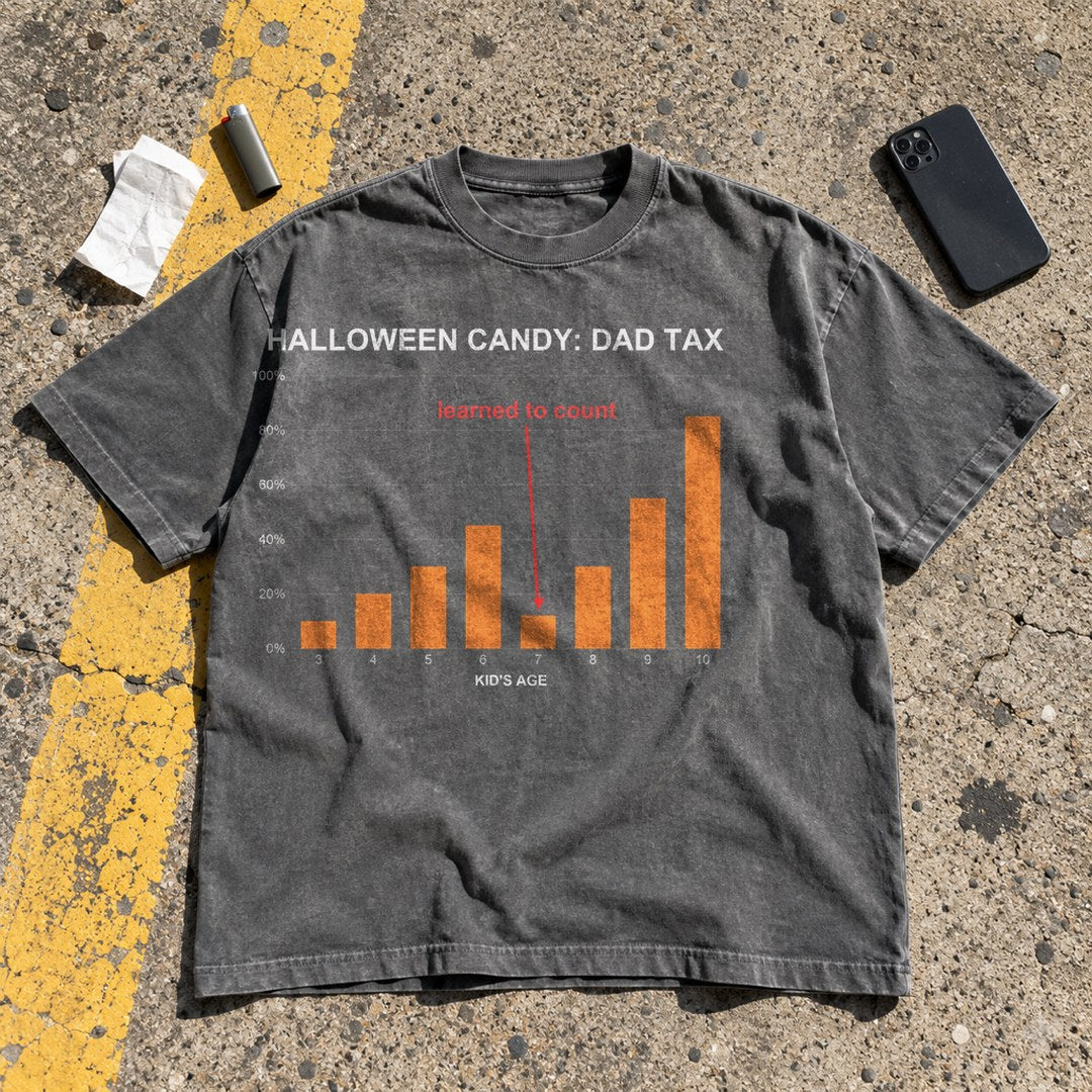 Halloween Candy Dad Tax Shirt laid flat in a parking lot