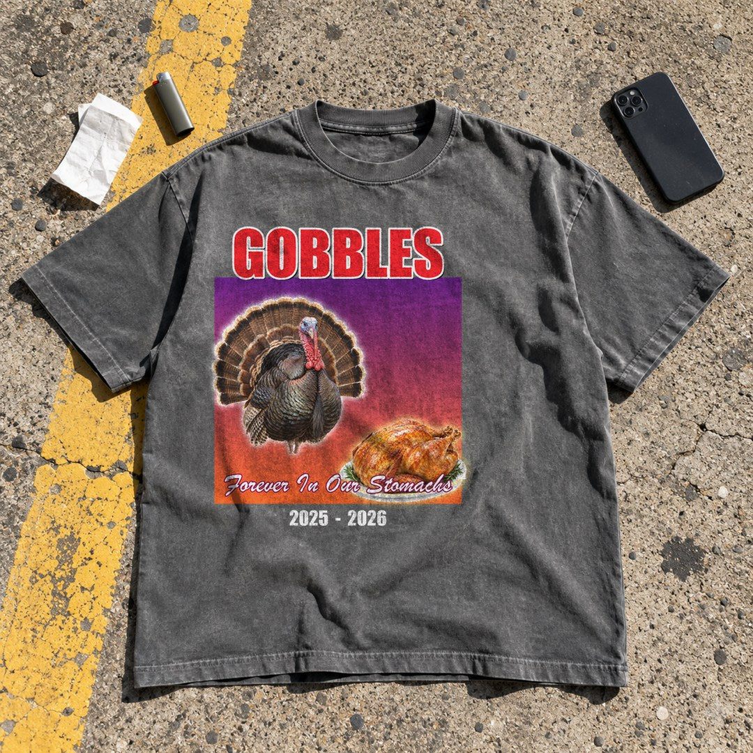 Gobbles Forever in Our Stomachs Shirt laid flat in a parking lot