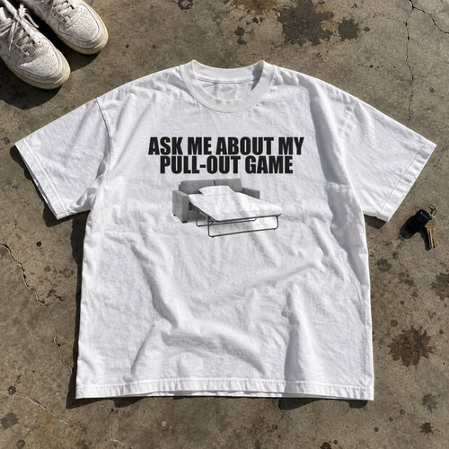 Ask Me About My Pull-Out Game Shirt laid flat on a concrete garage floor