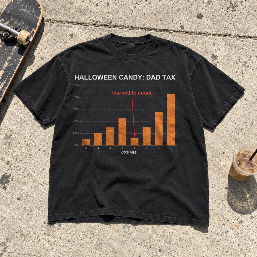 Halloween Candy Dad Tax Shirt laid flat on a sidewalk