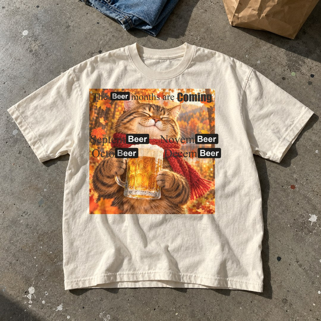 The Beer Months Are Coming Shirt laid flat on a concrete floor